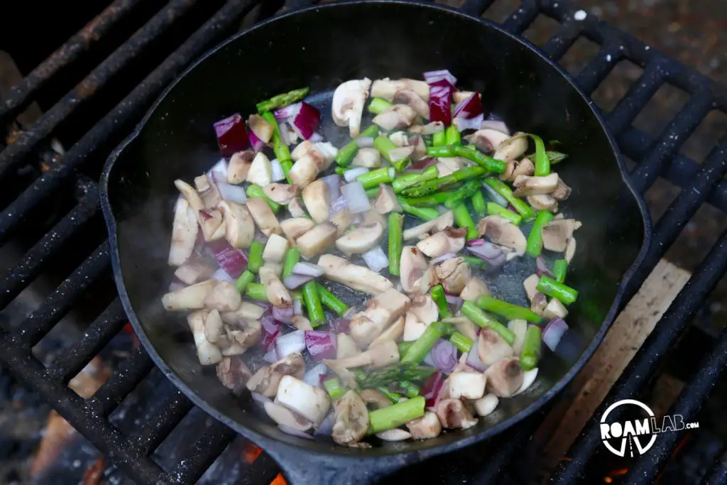 Sautéing vegetables before adding eggs.