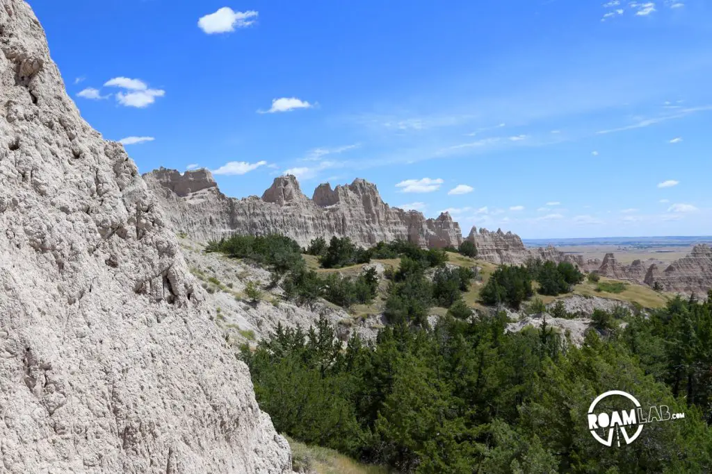A forest of juniper trees shade parts of the trail and cling to the sides of the majestic eroded bluffs.
