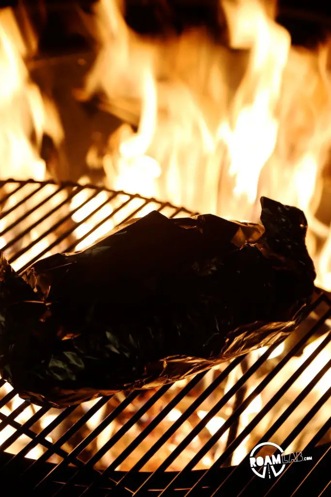 Toasting the Hiker’s Cheesy Ham Pretzel Roll over an open fire.