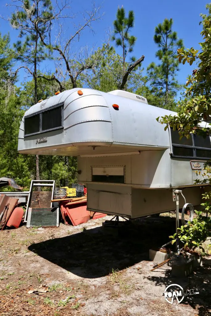 1970 Avion C11 truck camper floating on jacks in the back yard of its previous owner.