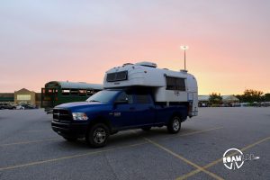 Sun setting over a 1970 Avion C11 truck camper parked in a Walmart Parking lot.