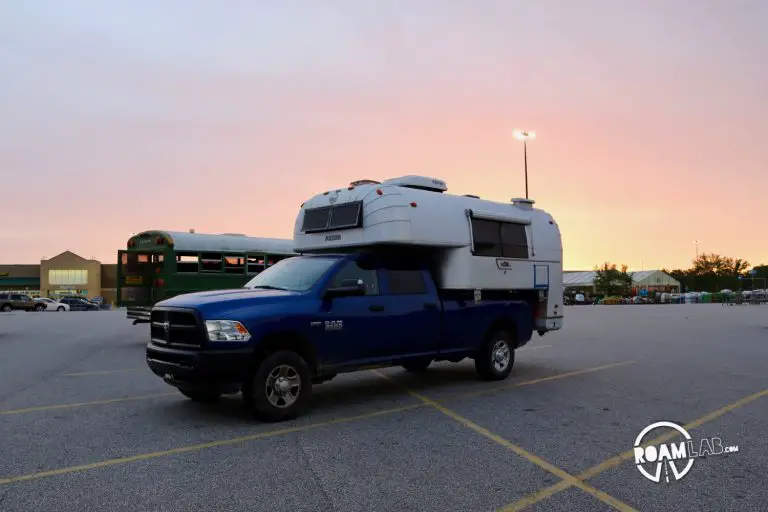 Sun setting over a 1970 Avion C11 truck camper parked in a Walmart Parking lot.