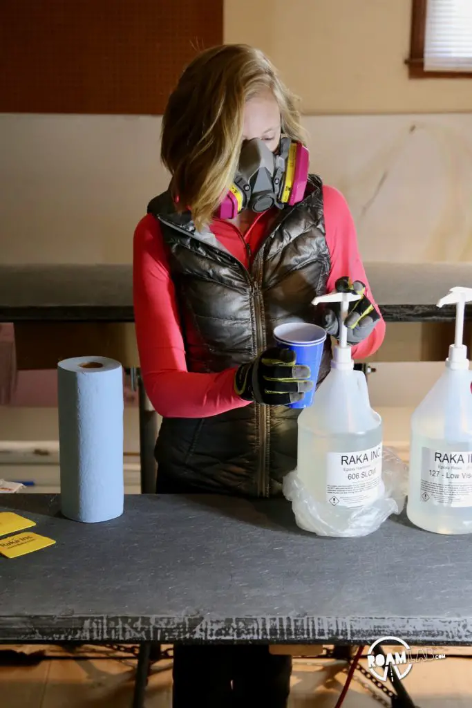 Measuring out two parts resin and one part hardener into a mixing cup.