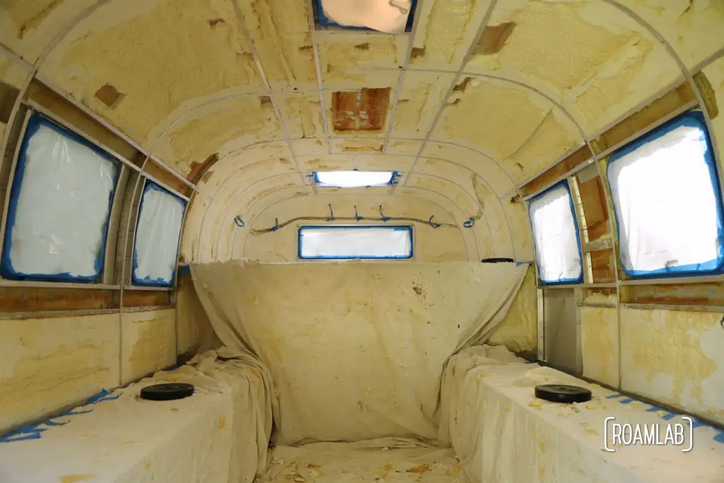 Camper interior taped off for insulation paint.