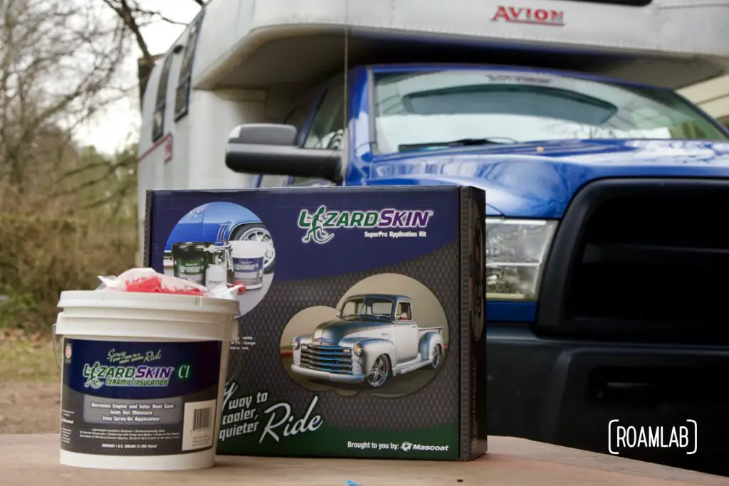 Paint bucket of Lizard Skin with a box of equipment and Avion C11 truck camper in the background.