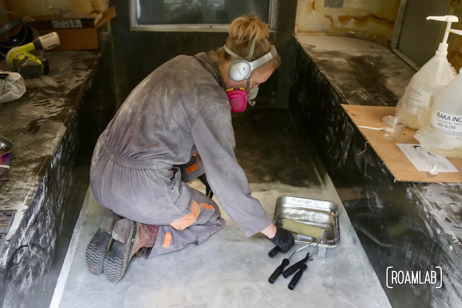 Rolling out air bubbles from fiberglass cloth to re-enforcing the truck camper floor.