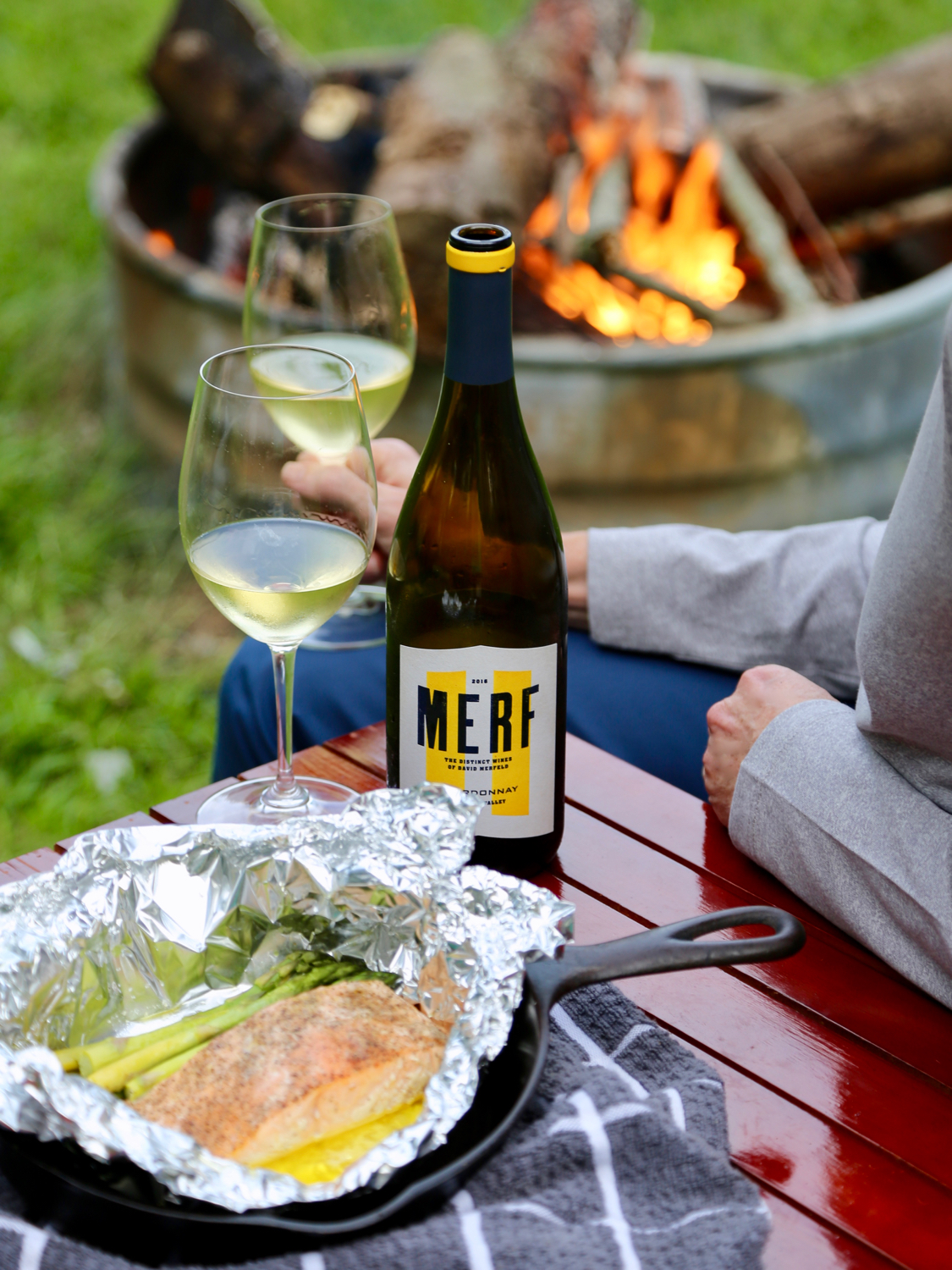 Glass of white wine enjoyed around with campfire with a salmon dinner