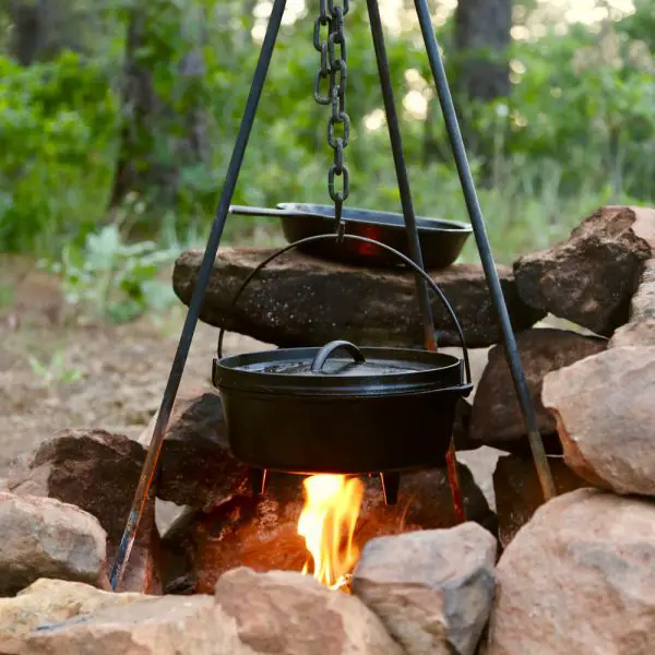 Cast iron dutch oven cooking over a campfire.