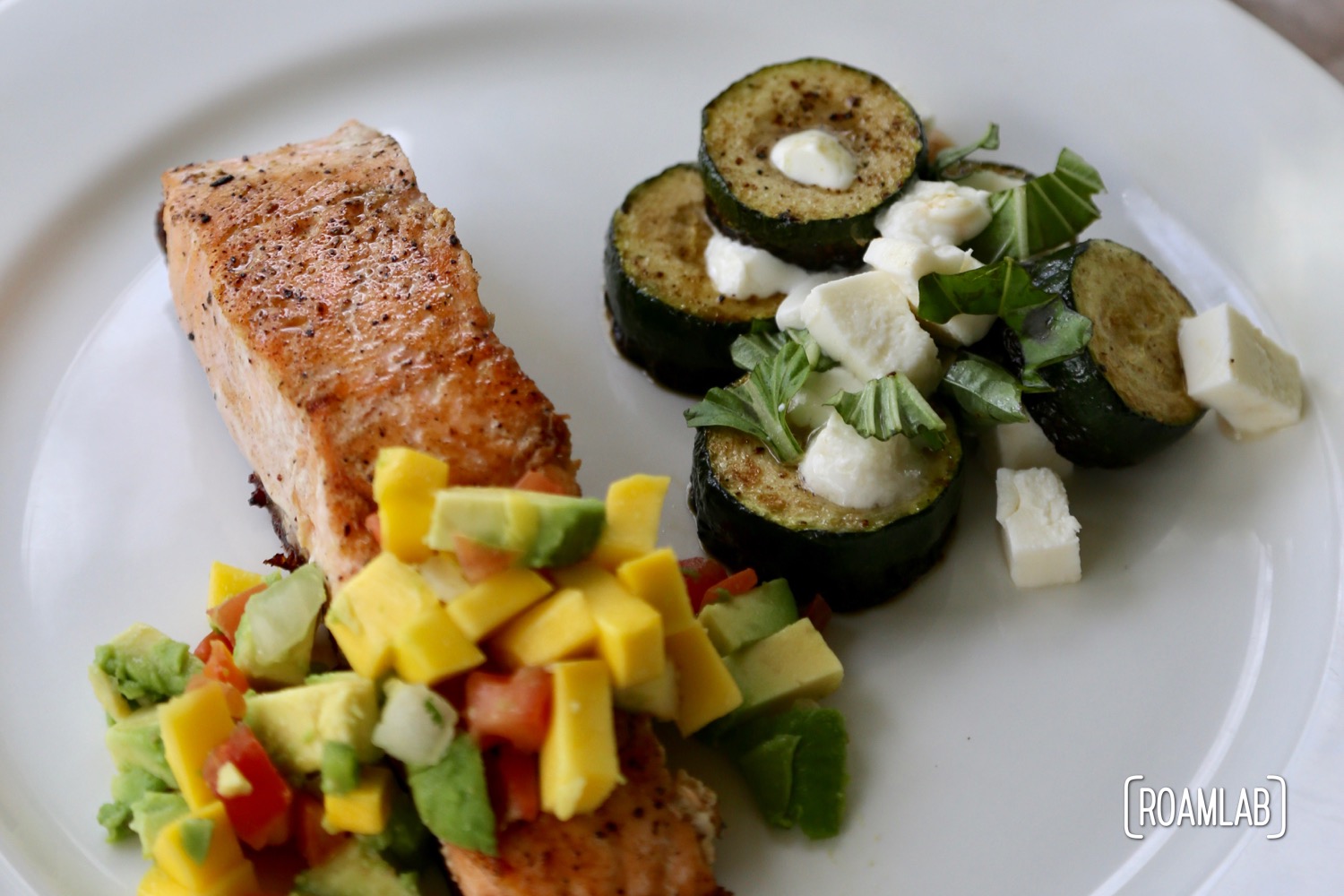 Cast iron skillet fried salmon with mango salsa and mozzarella zucchini.