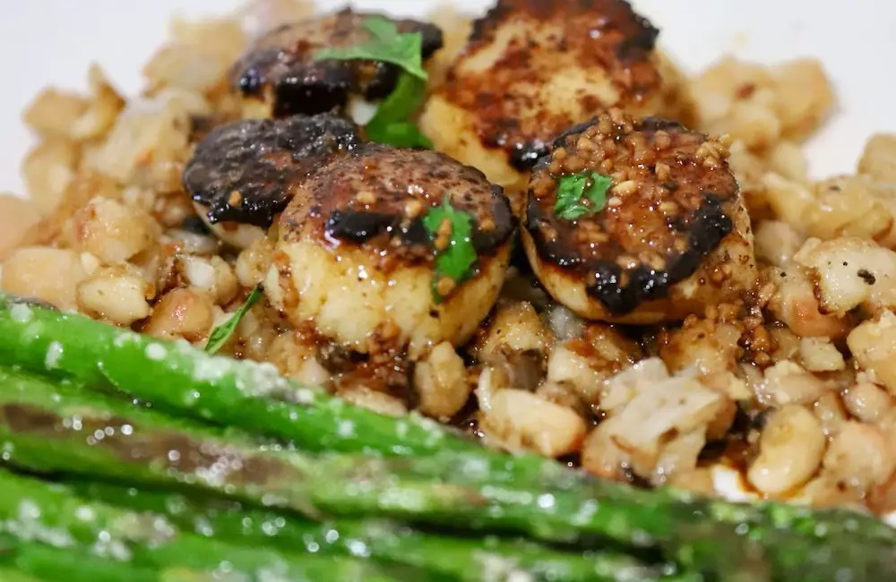 Enjoy this seafood delight of seared sea scallops on a bed of parmesan white beans for a campfire cooking dinner recipe treat from the Roam Lab team.