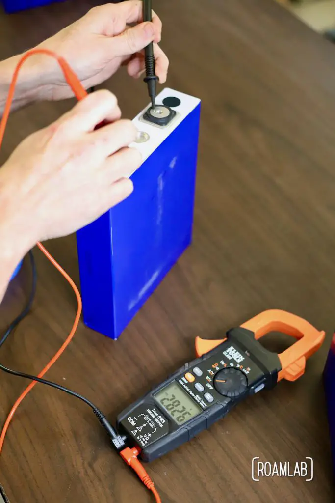 Checking the voltage of a battery cell.
