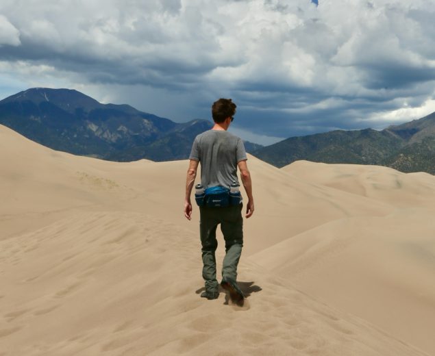 Man hiking to the mountains in the Great Sand Dunes National Park