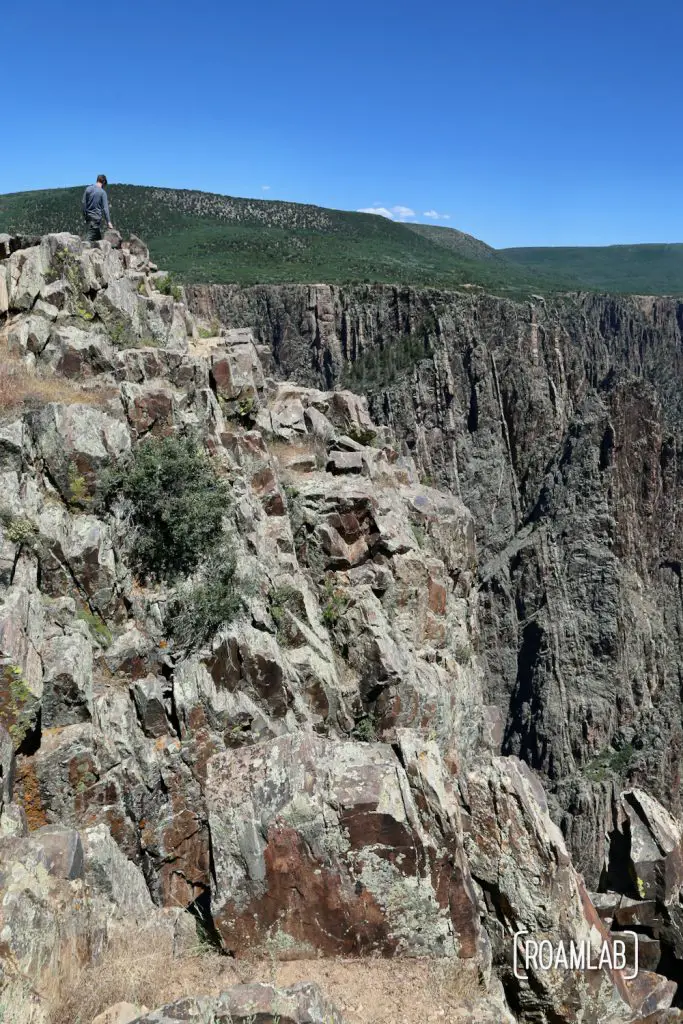 Chris standing at the top of a cliff looking down into the Black Canyon of the Gunnison National Park in Colorado