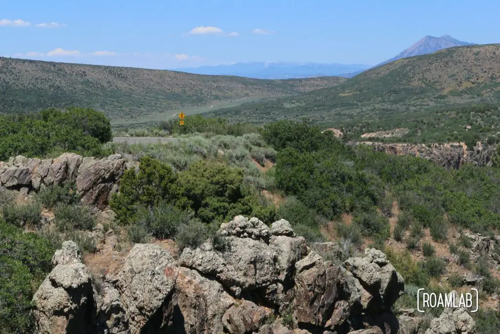 The green, rolling hillsides mask the canyon in between at the Black Canyon of the Gunnison National Park in Colorado