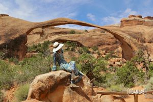 Woman in front of Landscape Arch in the Devil's Garden of Arches National Park, Utah.