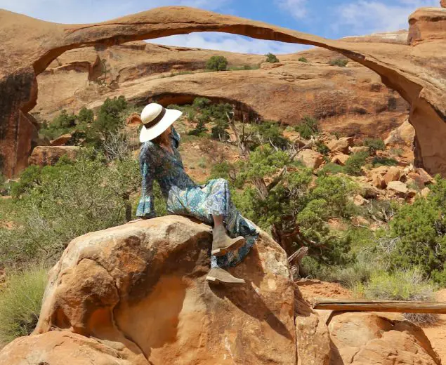 Woman in front of Landscape Arch in the Devil's Garden of Arches National Park, Utah.