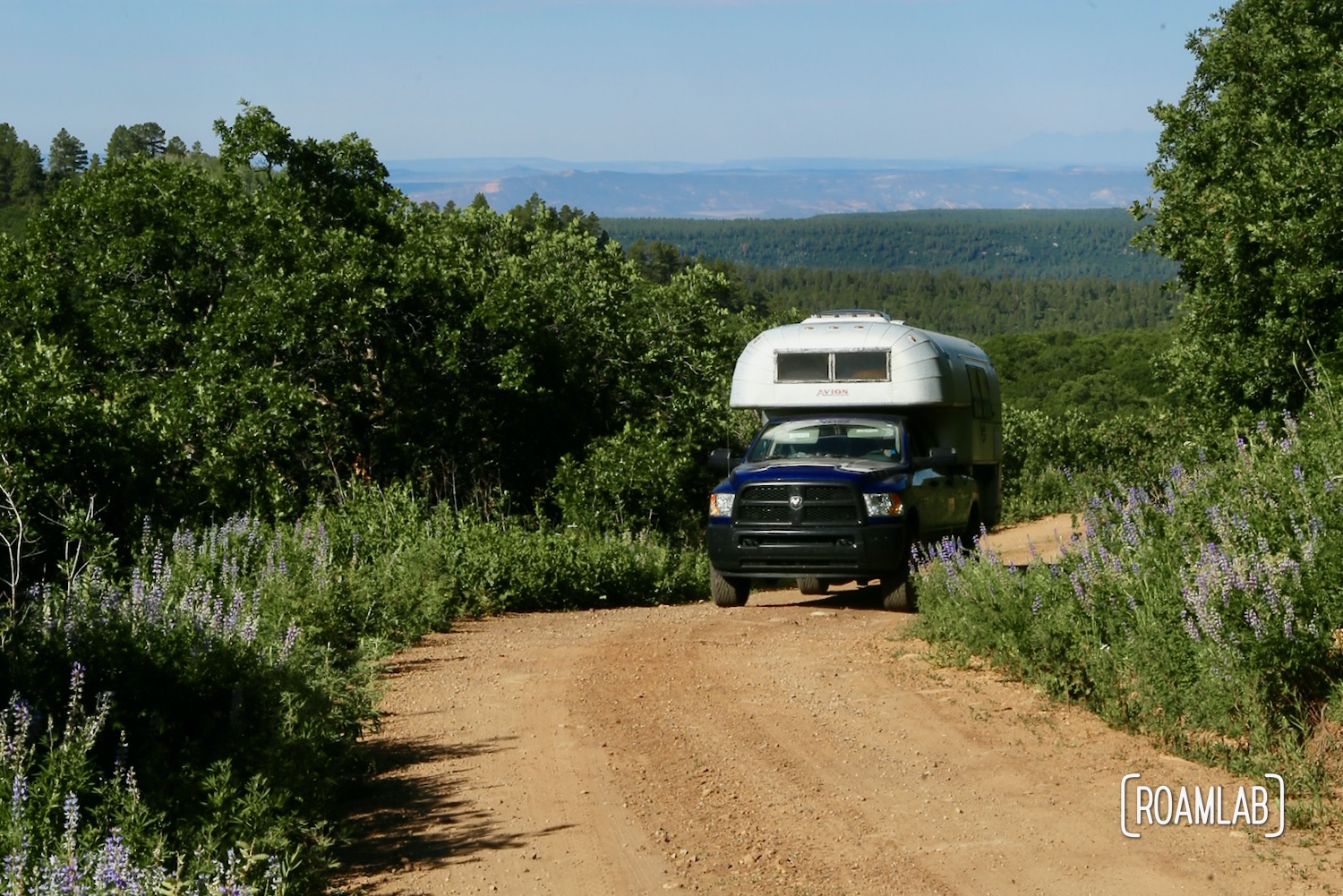 Vintage 1970 Avion C11 truck camper driving down a dirt road on the Rimrocker off-road and OHV trail.