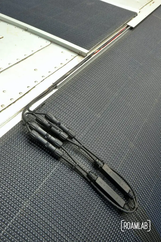 Wires routed from solar panels through an aluminum rail.
