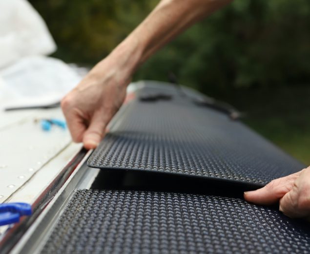 Carefully placing panels on truck camper roof and securing with velcro.