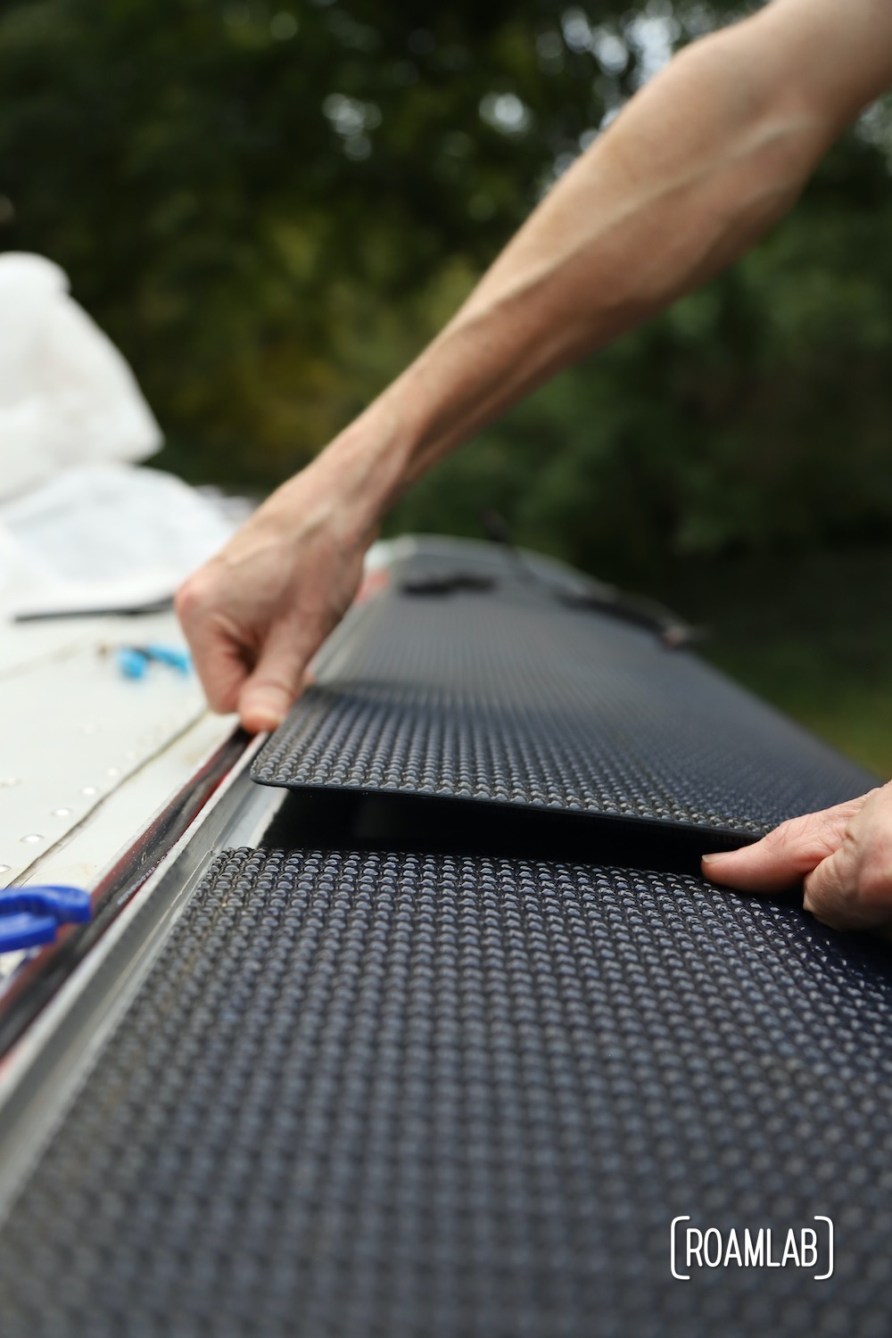 Carefully placing panels on truck camper roof and securing with velcro.