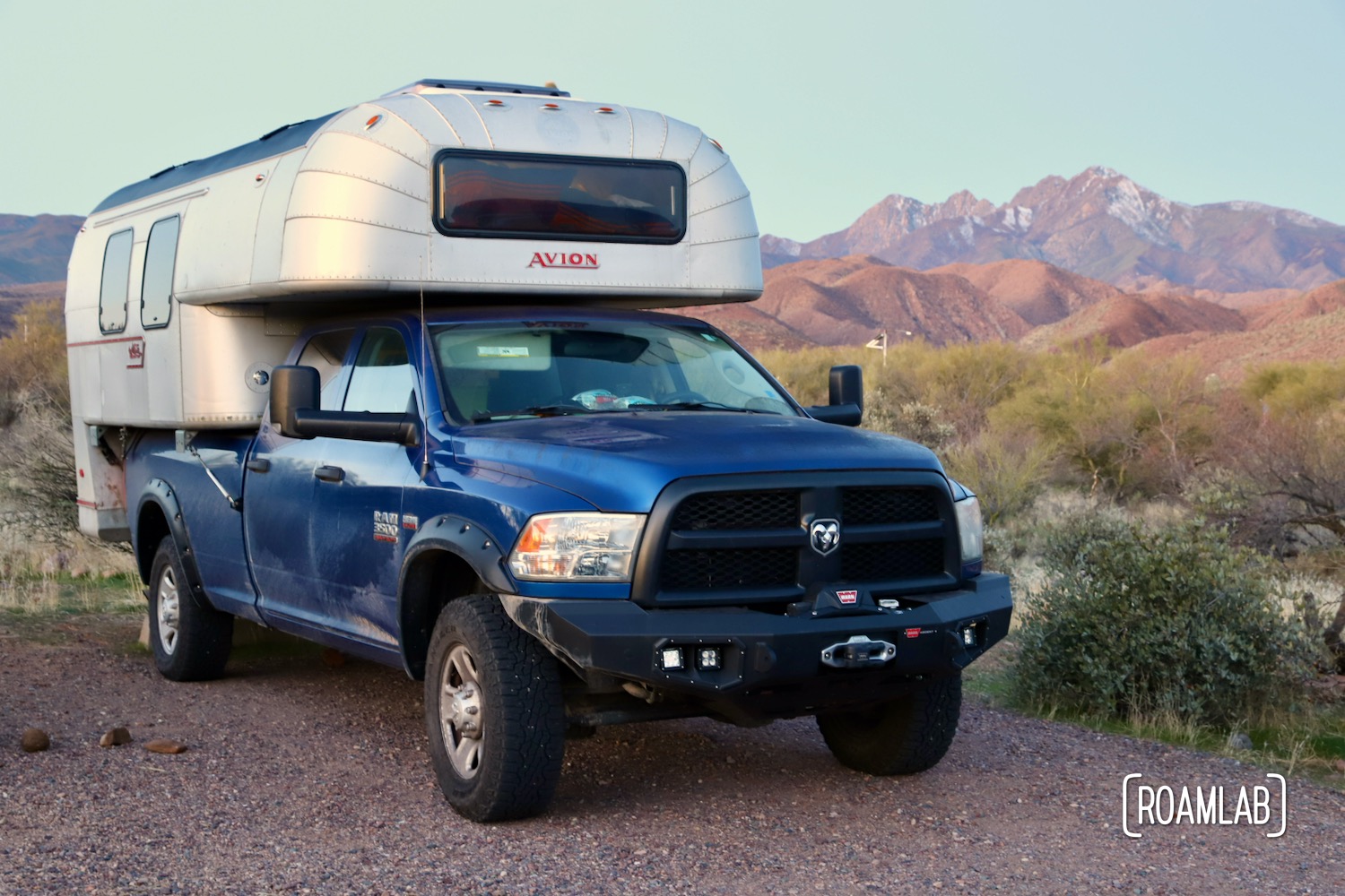 1970 Avion C11 truck camper on a blue truck with purple mountains in the background.