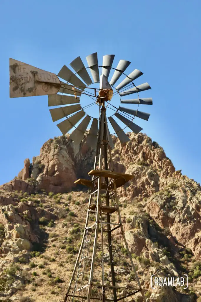 Faraway Ranch windmill with rocky hilltop in the background along the Silver Spur Meadow Trail in Chiricahua National Monument Arizona.