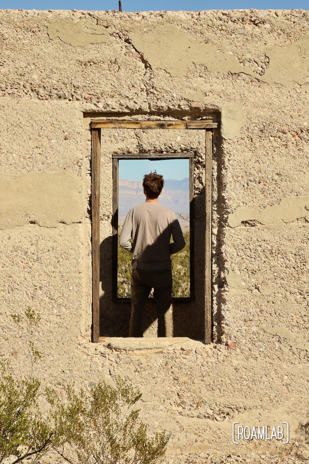 Man framed in the windows of an old stucco building.