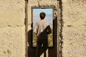 Man framed in the windows of an old stucco building.
