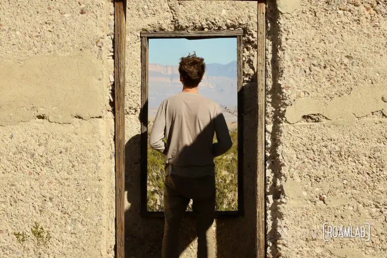 Man framed in the windows of an old stucco building.