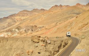 1970 Avion C11 truck camper driving through Artist's Road in Death Valley National Park.