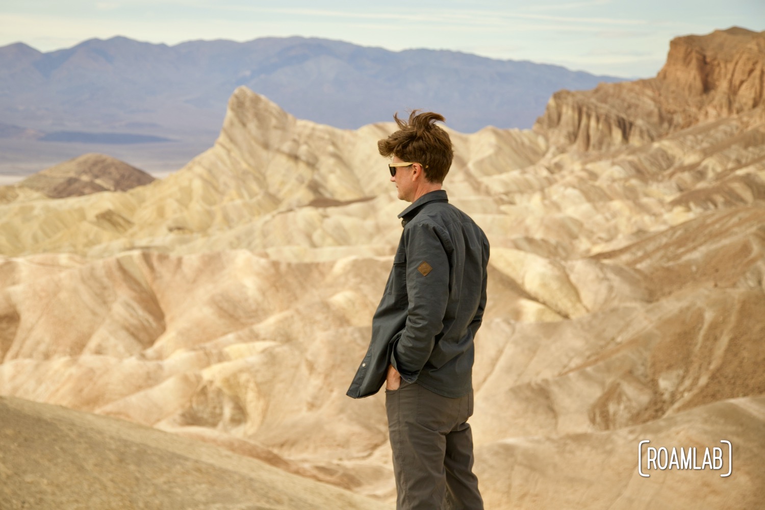 Man standing in front of a rock formation at Zabrinskie Point, Death Valley National Park, California