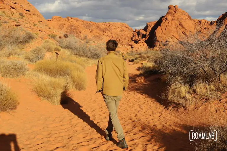 Man walking through the red sand on Mouse Tank Trail of Valley of Fire State Park