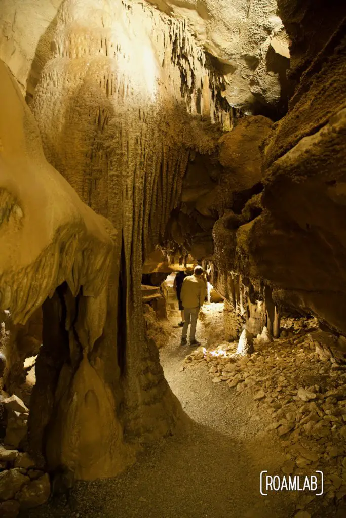 Man ducking below a low hanging section of rock in Crystal Onyx Cave.