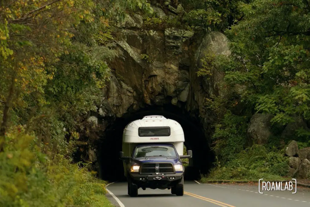 Vintage 1970 Avion C11 truck camper driving through a tunnel in Shenandoah National Park.