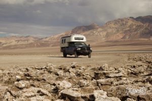 1970 Avion C11 truck camper parked in the Devil's Golf Course with the Amargosa Range in the background.