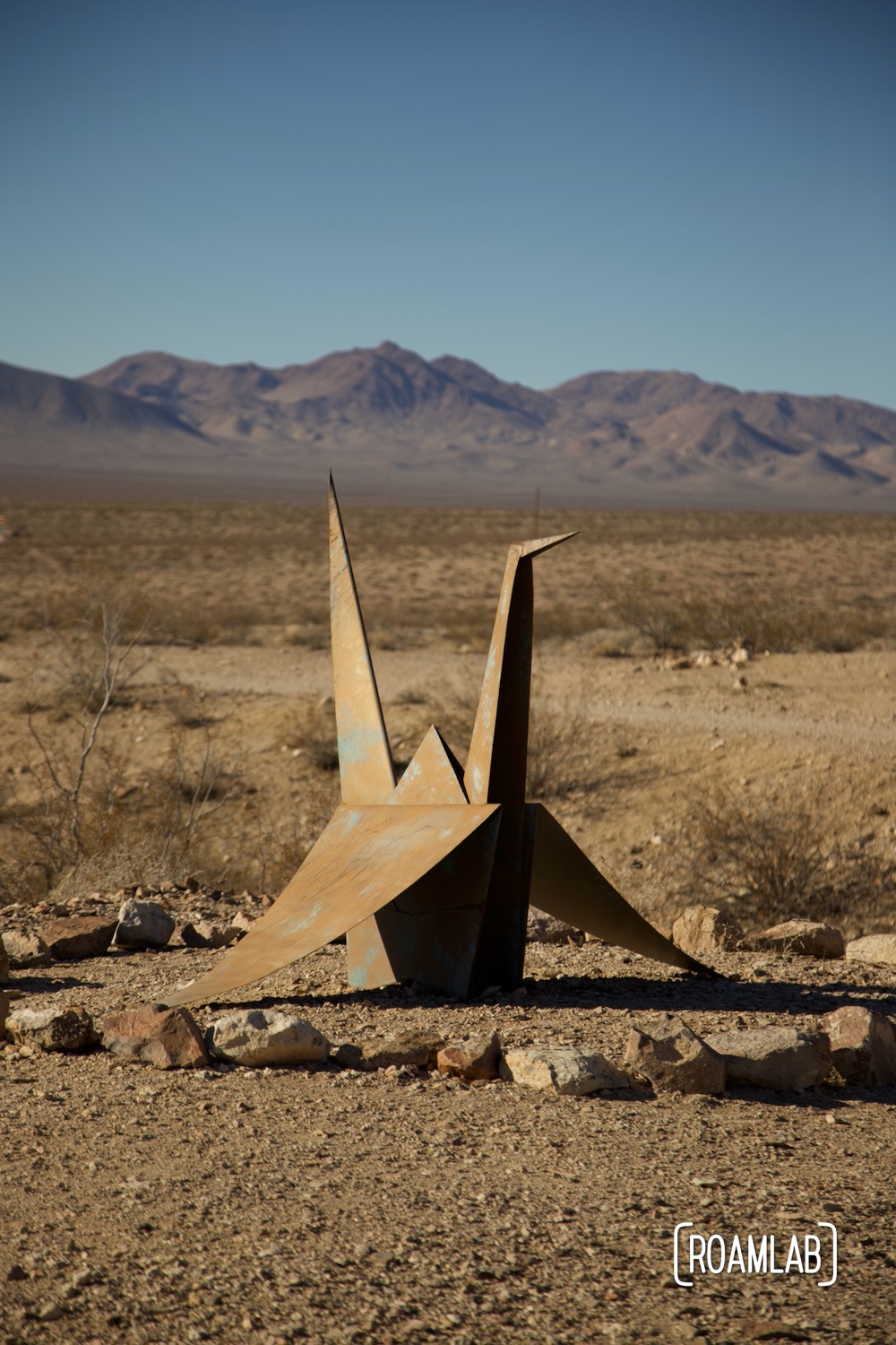 Painted steel squares zig zag on the desert floor with a pixilated cinderblock Venus in the background.