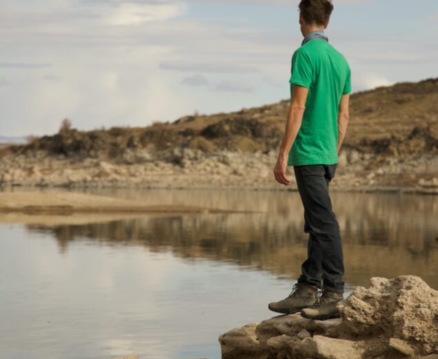 Man in a green shirt looking out over Elephant Butte Lake.