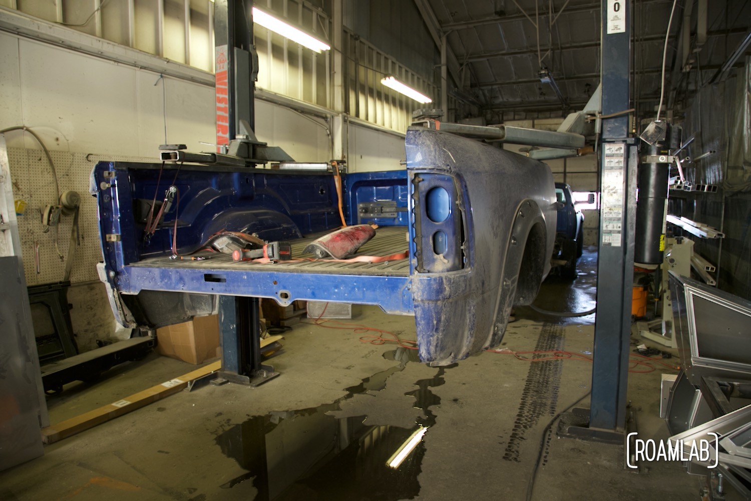 Blue Ram 3500 truck bed suspended on a lift.