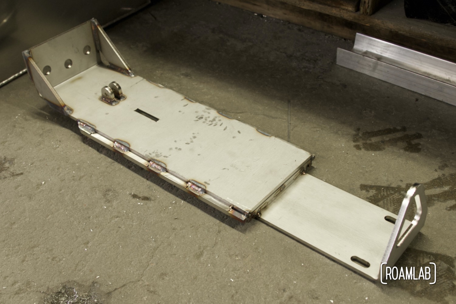Quick release stainless steal jack point sitting on concrete floor.