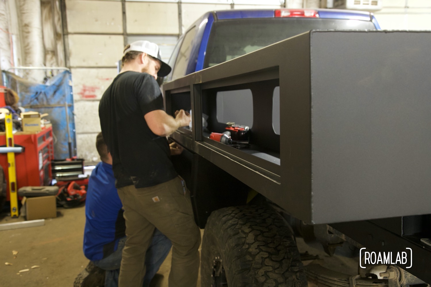 Two men bolting upper boxes on a custom custom utility bed.