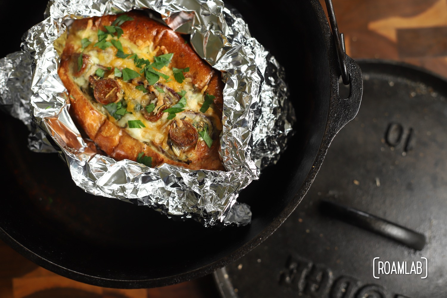 Freshly baked Egg Boat wrapped in tin foil in a cast iron dutch oven.