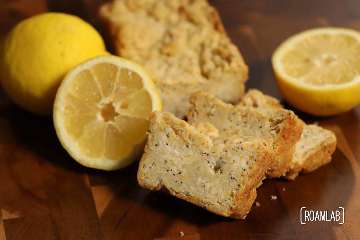 Lemon Poppyseed Squash Bread on a cutting board with lemons.