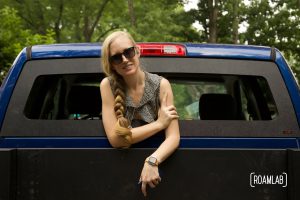 Woman leaning out an open rear truck window.