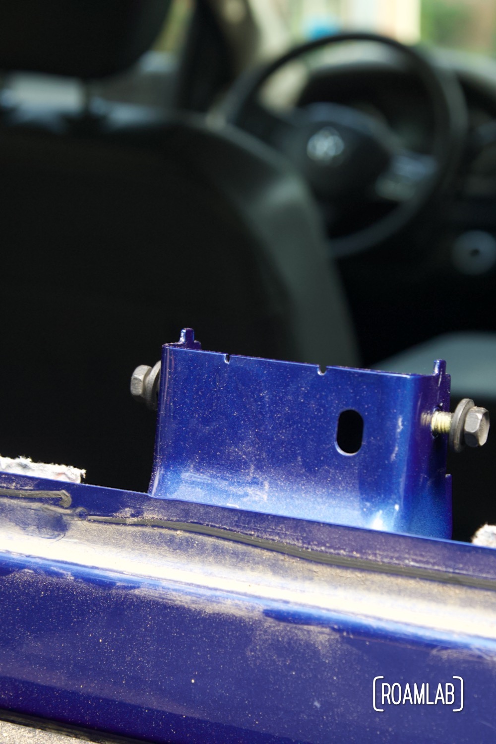 Traces of urethane remain along the blue metal lip of the truck rear windshield.