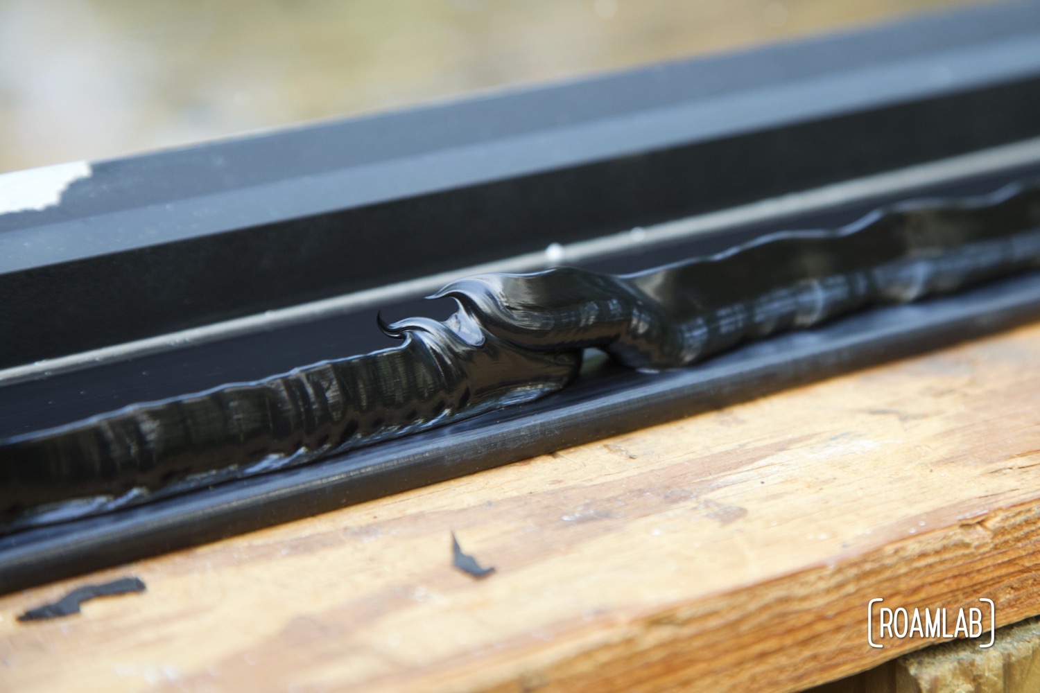 Imperfect peaked bead of urethane on the edge of a truck window.