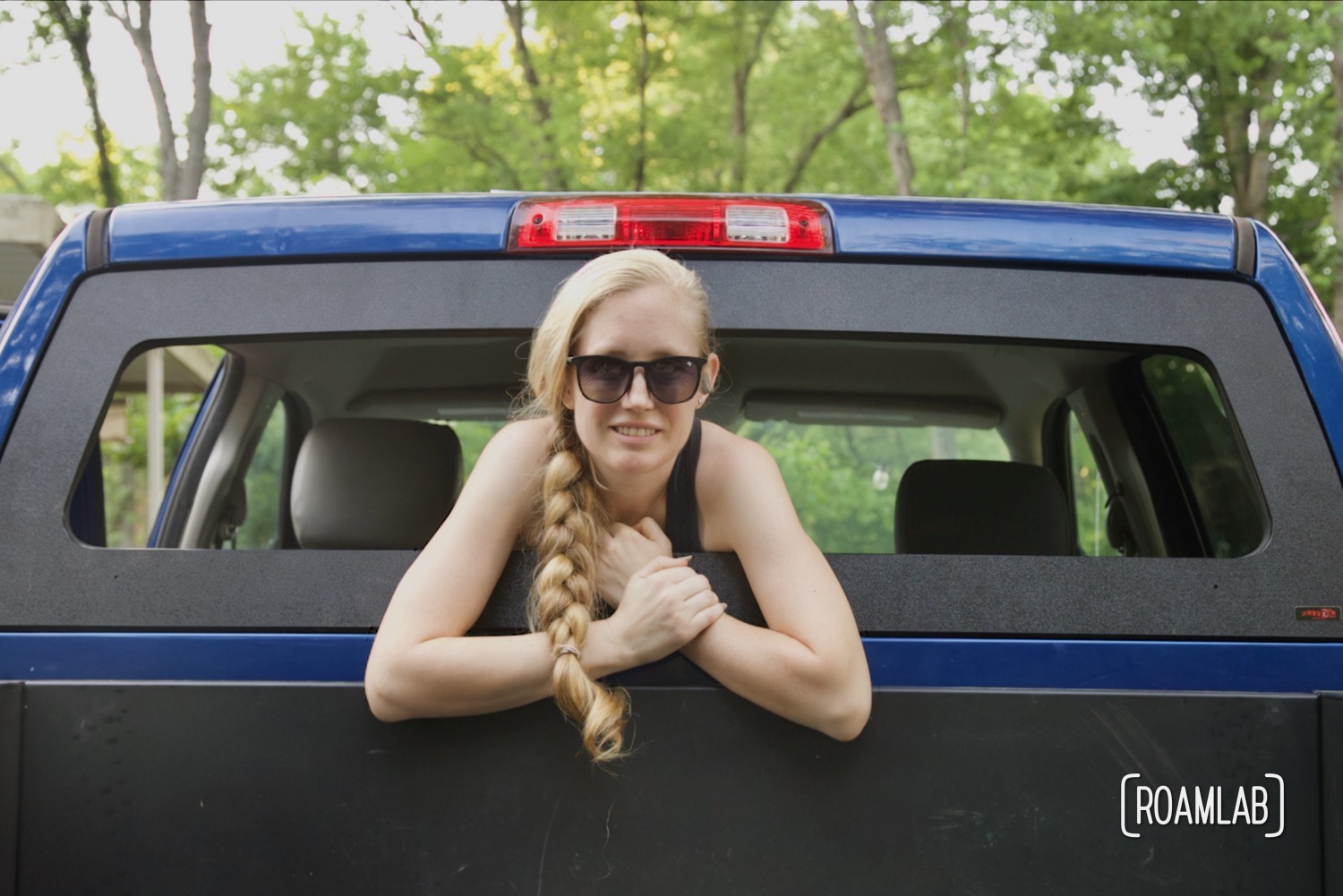 Woman leaning out of a truck rear window.