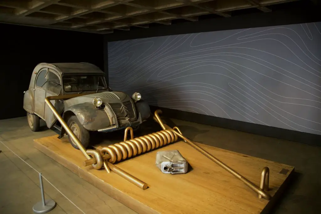 Citroen 2CV captured in a giant mouse trap with gasoline as the bate.