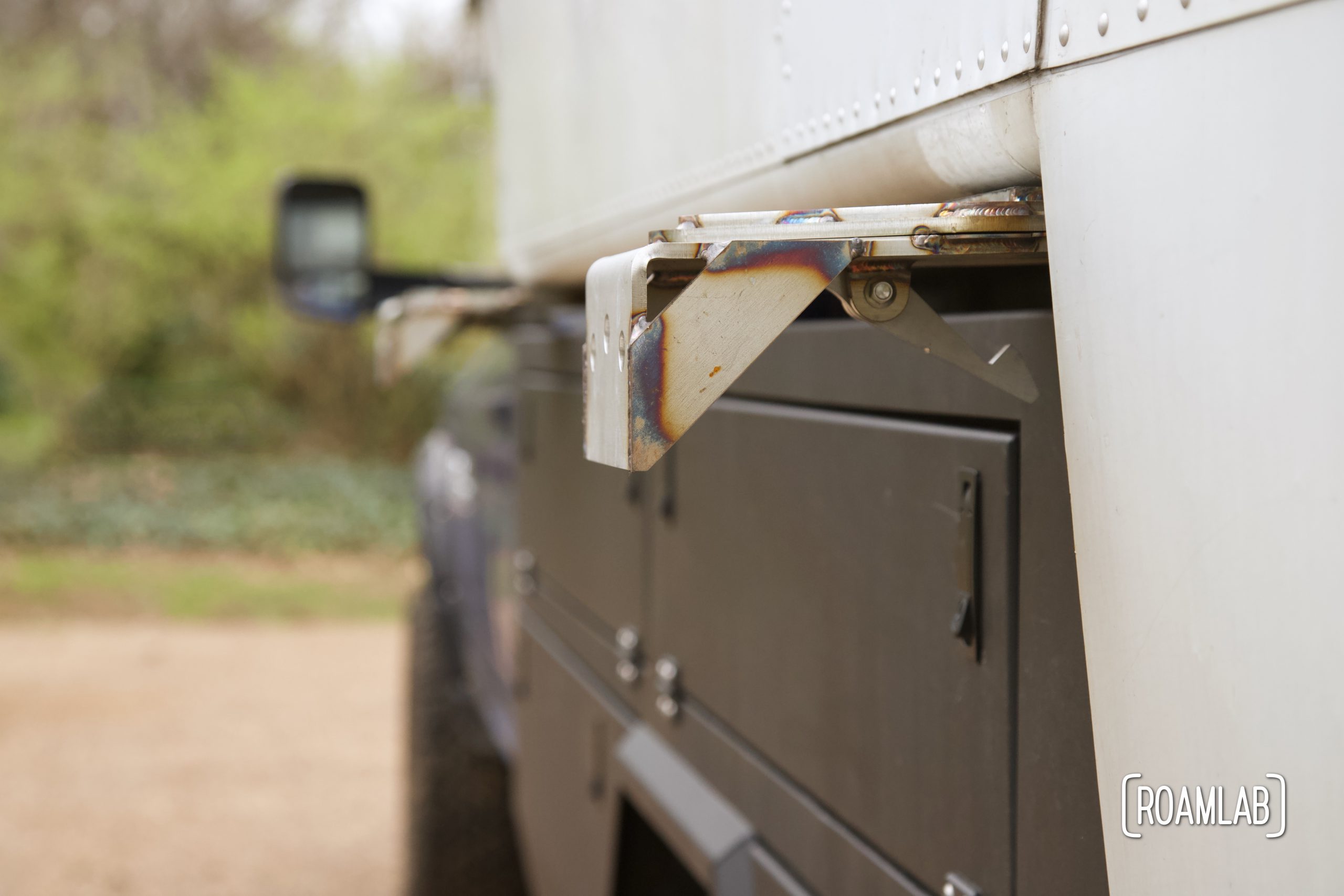 Side view of Removable jack mount bracket attached to truck camper wing and Bowen Customs truck bed.
