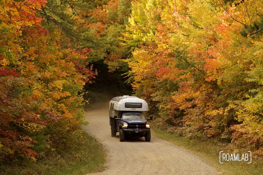 1970 Avion C11 truck camper driving down the dirt Old North Carolina 105 in Linville Gorge Wilderness Area.