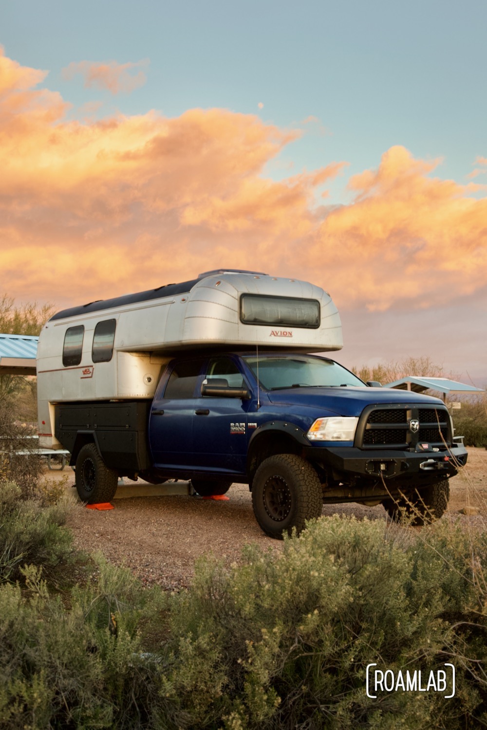 Avion C11 truck camper surrounded by wild sage and pink clouds at sunrise.